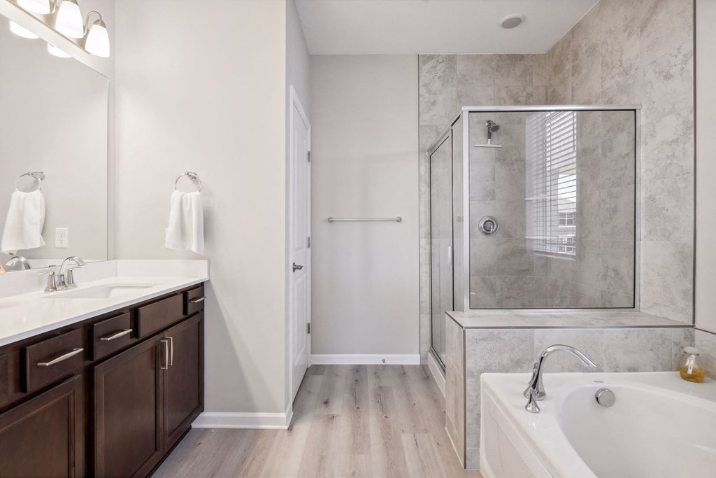 a bathroom with a tub and a shower and a sink