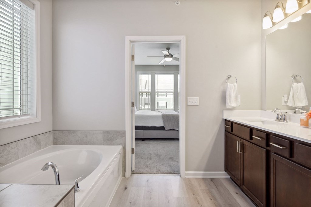 a bathroom with a tub and a sink and a mirror