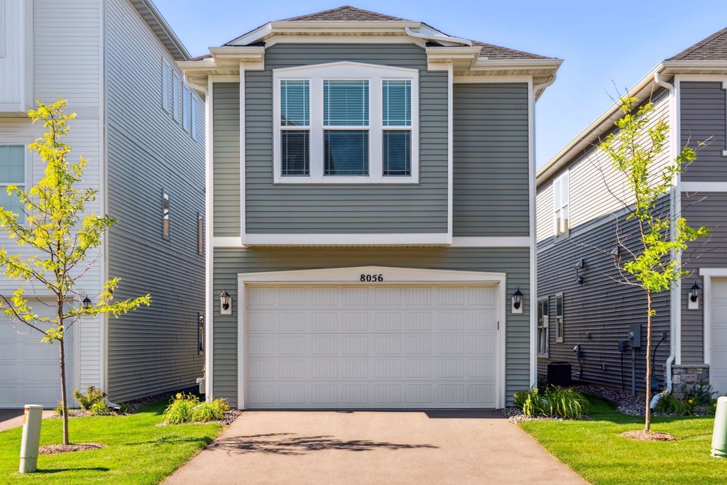 a blue house with a garage door in front of it