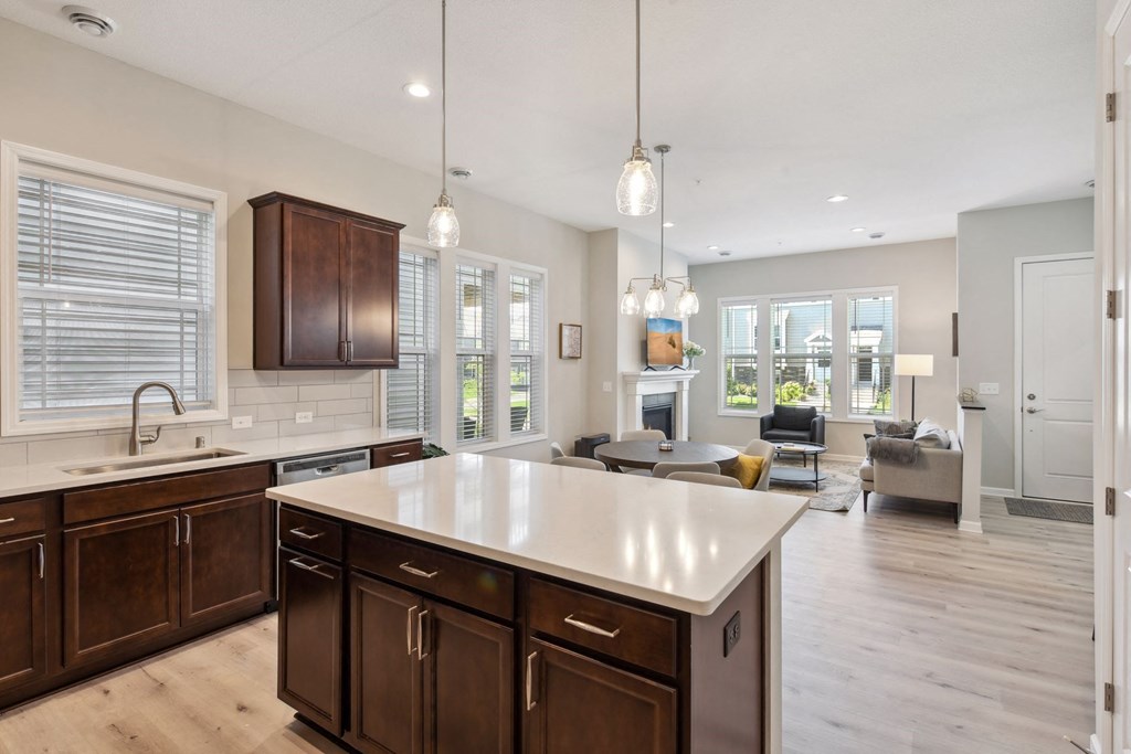 an open kitchen and living room with a large white counter top