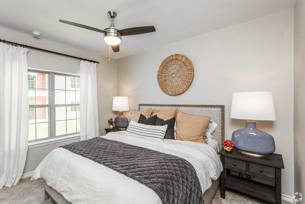 a bedroom with a bed and a ceiling fan