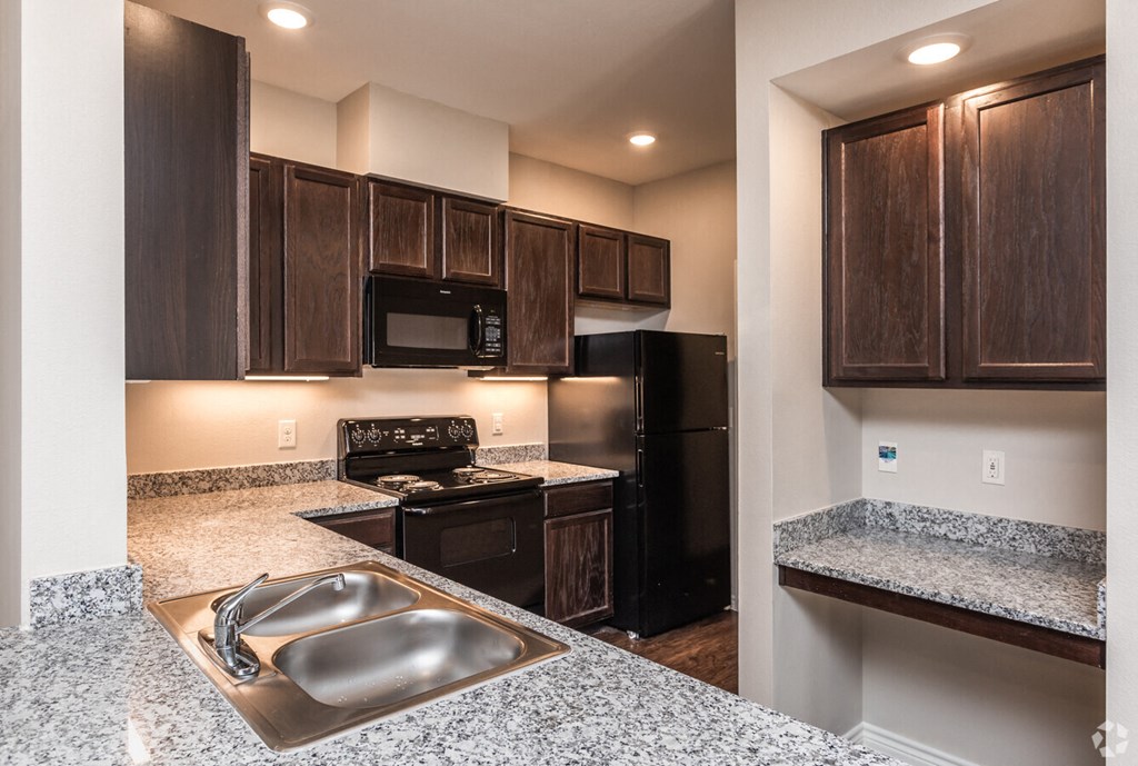 a kitchen with black appliances and granite counter tops
