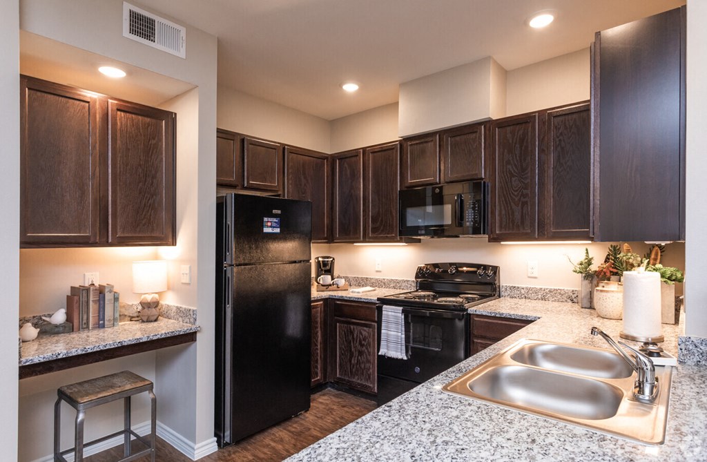 a kitchen with black appliances and granite counter tops