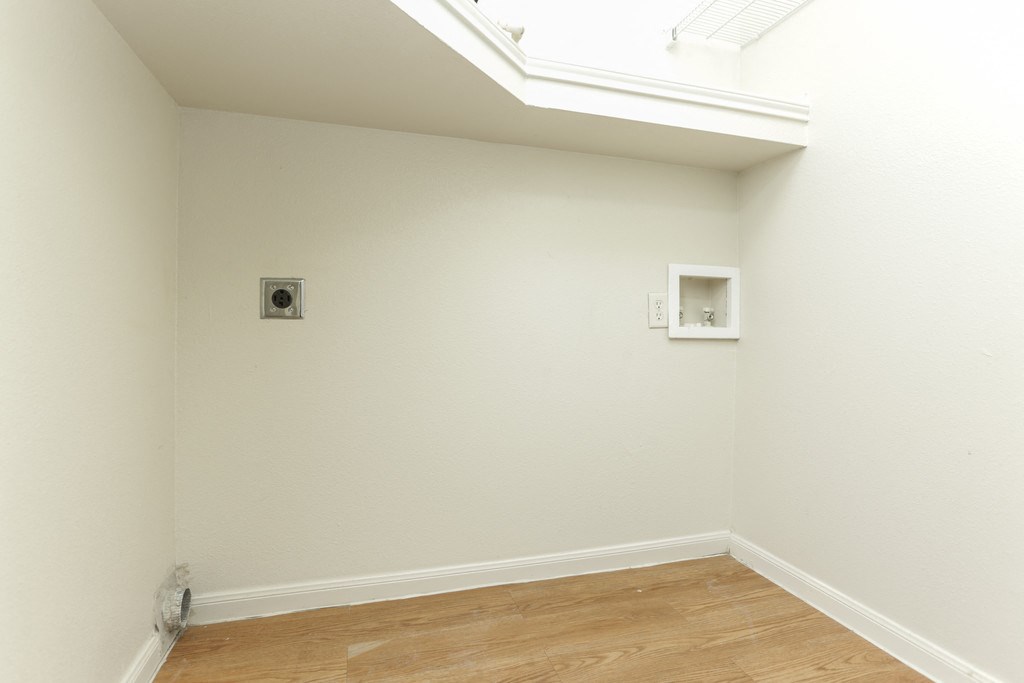 a room with white walls and a window and a wood floor