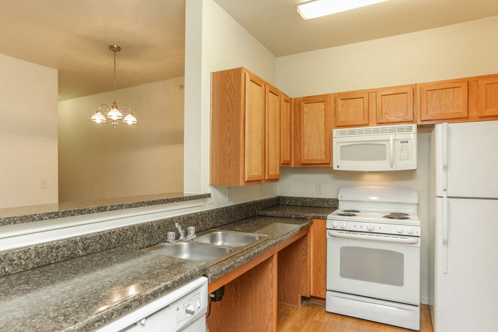 a kitchen with white appliances and granite counter tops