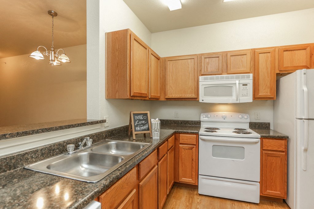 a kitchen with a sink stove and microwave and wooden cabinets