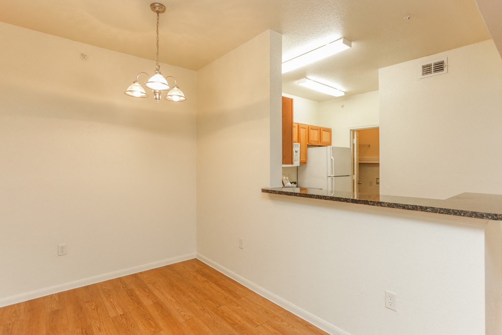 the spacious living room and kitchen of an empty apartment