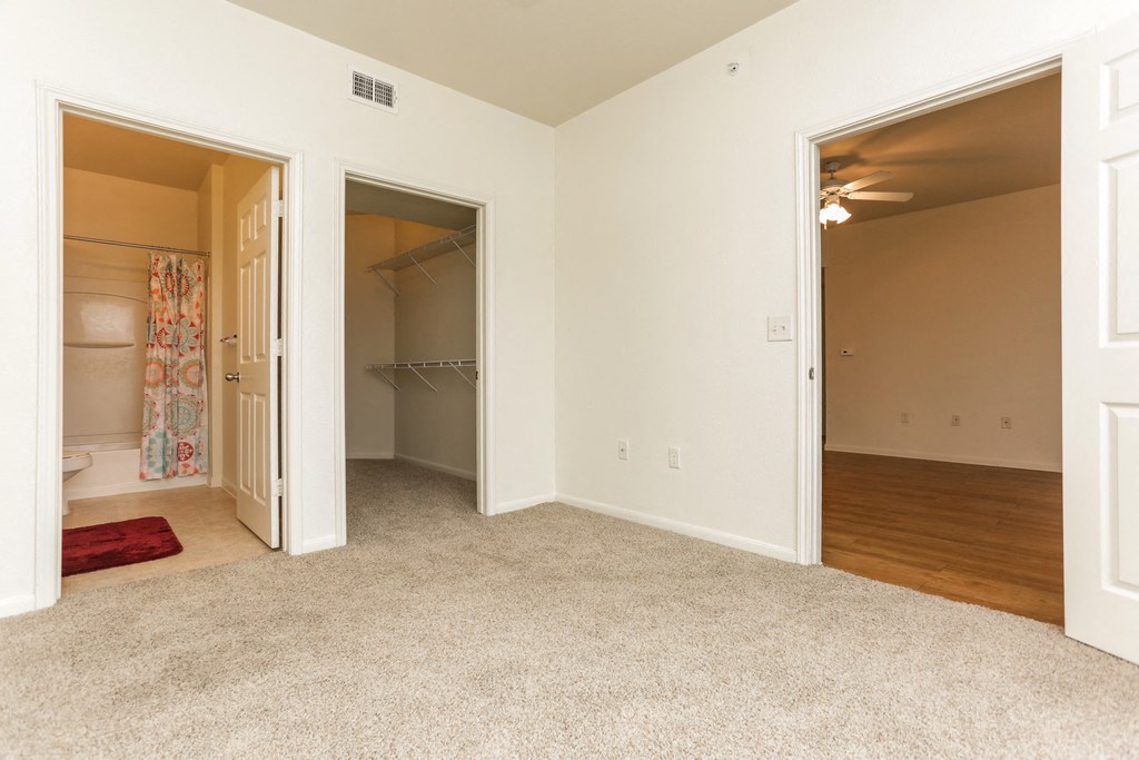 an empty bedroom with a closet and a bathroom