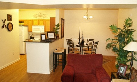 a living room and dining room with a table and chairs