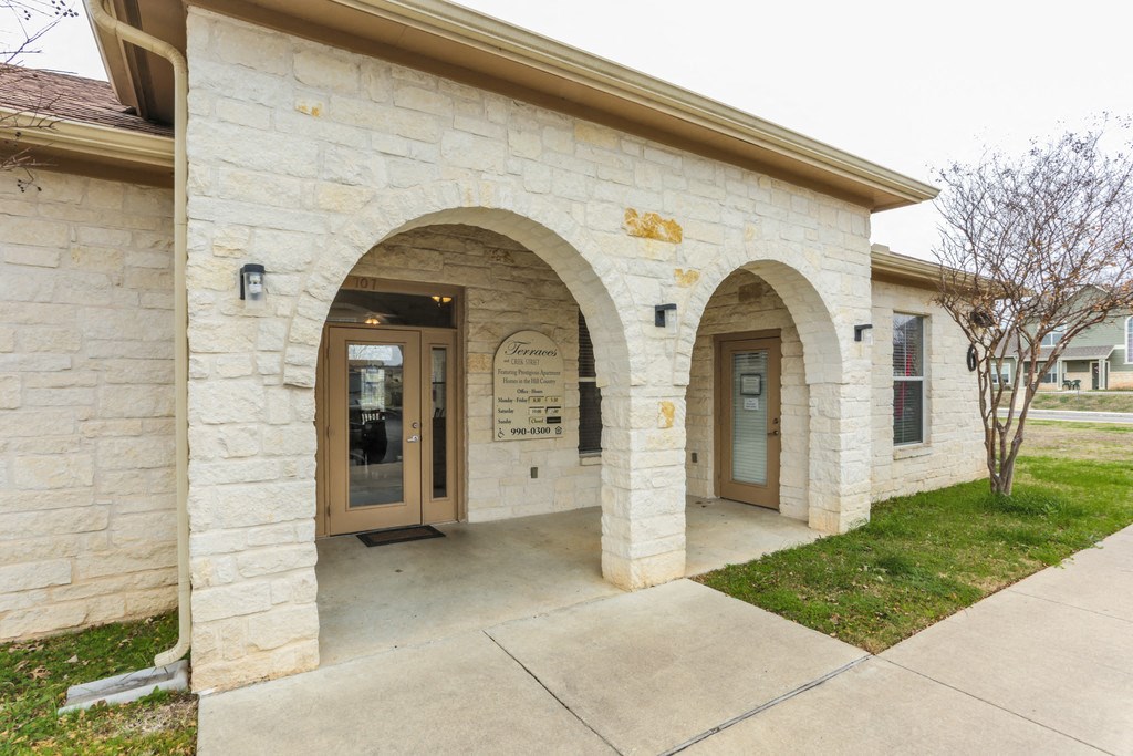 the front entrance of a stone building with two doors