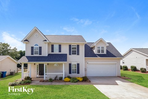 a white house with a blue roof and white garage doors