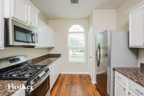 A kitchen with a black stove top oven and a black microwave.