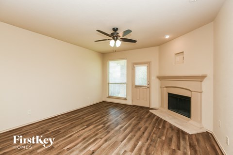 a living room with a fireplace and a ceiling fan