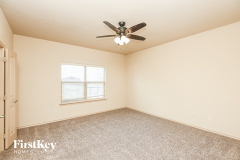 a bedroom with a ceiling fan and a window