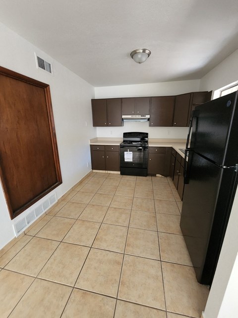 a kitchen with a black refrigerator and a black stove