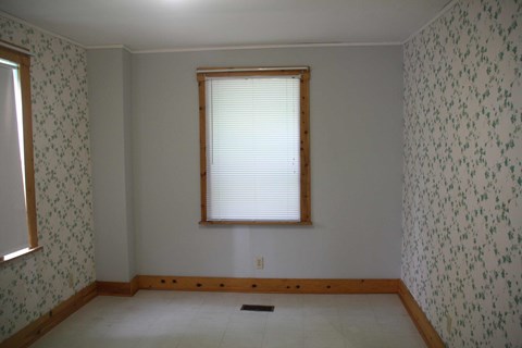 the dining room before the removal of the wallpaper and window