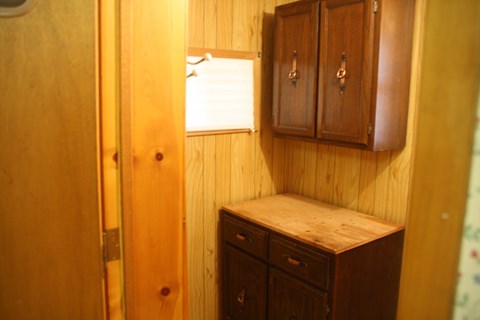 a small bathroom with wooden cabinets and a window