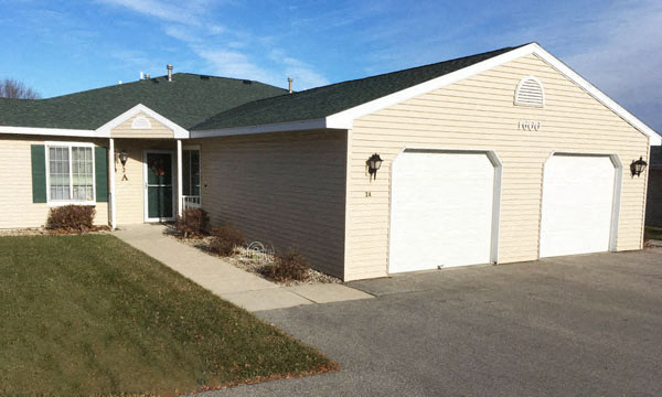 a house with two garages and a driveway in front of it