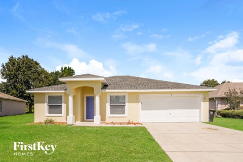 a home with a lawn and a white garage door