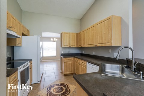 a kitchen with wooden cabinets and a sink and a refrigerator