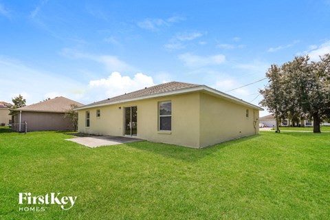 a small yellow house with a grass yard and a blue sky