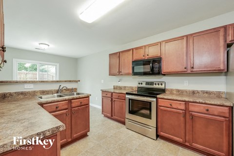 A kitchen with brown cabinets and a granite counter top.