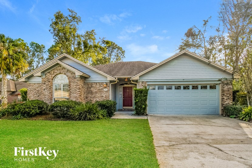 a brick house with a blue garage door and a lawn