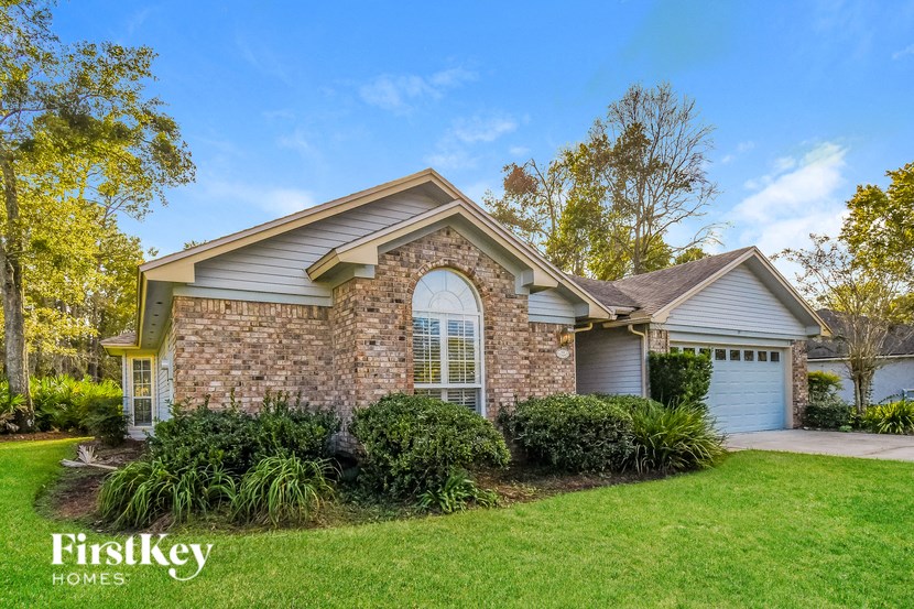 the front of a house with a lawn and a driveway