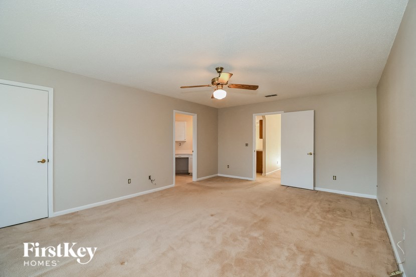 a empty living room with a ceiling fan