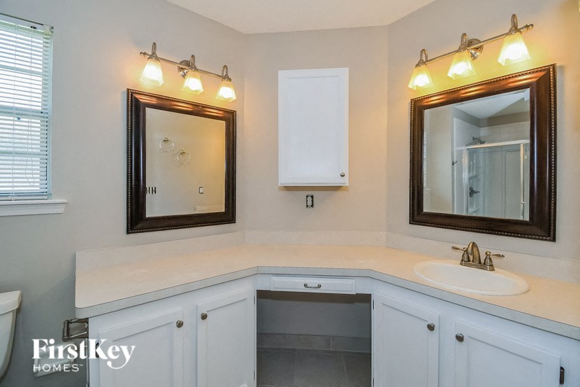 a white bathroom with two mirrors and a sink