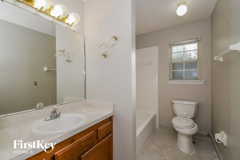 a bathroom with a toilet and a sink and a mirror
