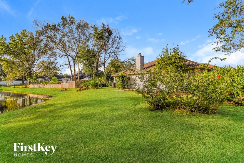 a backyard with a pond and a house