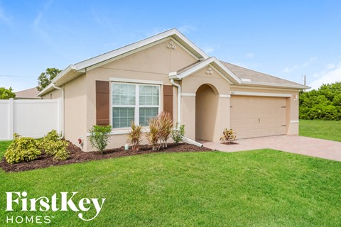 a beige house with a lawn in front of it
