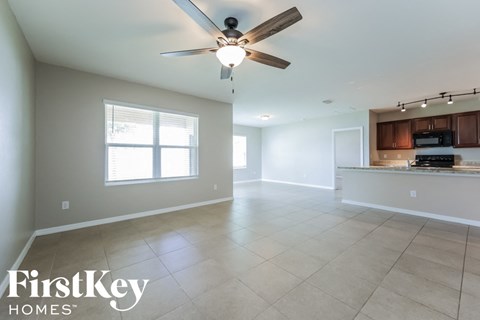 an empty kitchen and living room with a ceiling fan