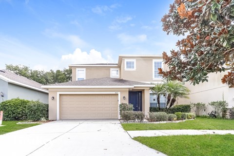 A two-story house with a garage and a driveway.