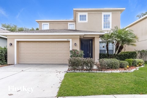A two-story house with a garage and a driveway.