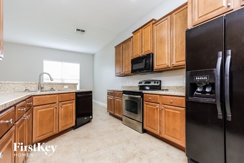 A kitchen with wooden cabinets and black appliances.