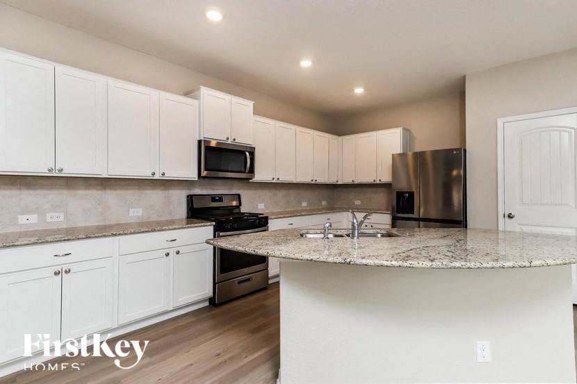a kitchen with white cabinets and a granite counter top