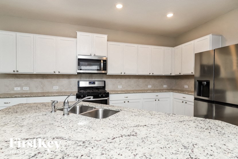 a kitchen with white cabinets and granite counter tops