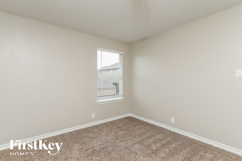 a bedroom with carpet and a window