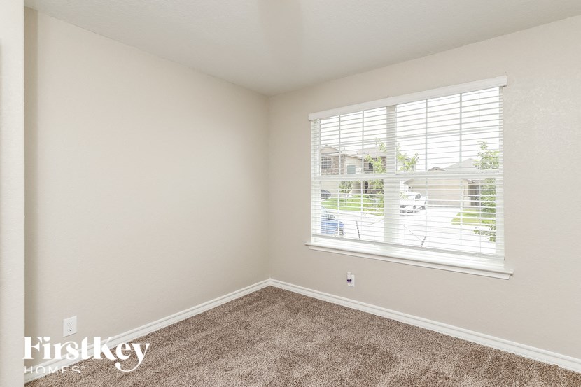 a bedroom with a large window and carpeting