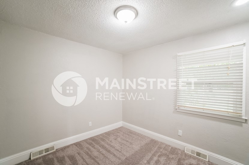 a bedroom with a carpeted floor and a window