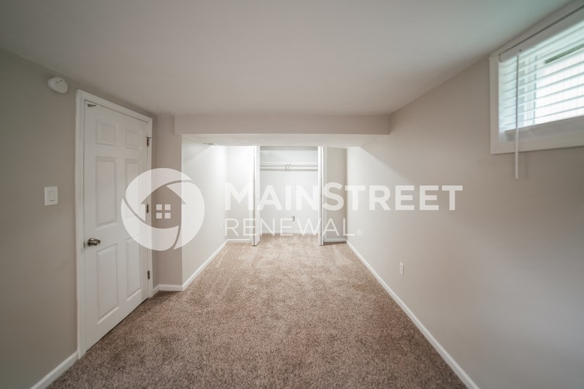 a bedroom with a white door and a carpeted floor