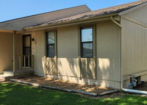 the front of a house with a porch and grass