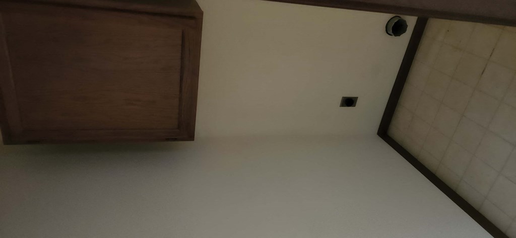 an empty room with white walls and a cabinet