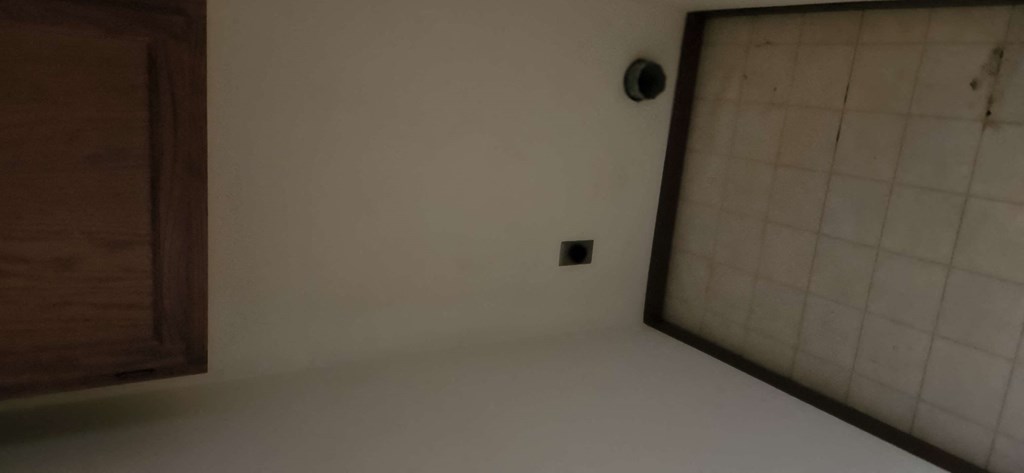 an empty room with a sink and a mirror