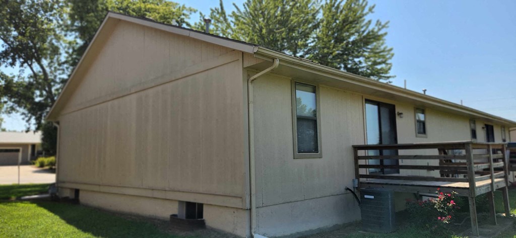 the front of a mobile home with a wooden deck