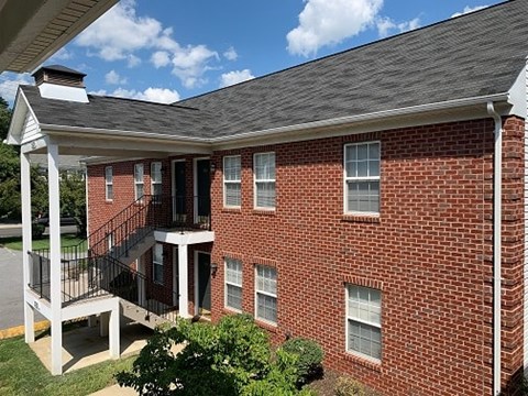 A red brick house with a balcony.