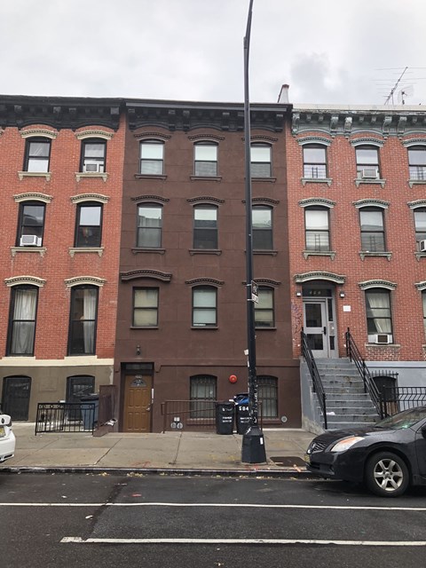 A street view of a row of brown brick buildings.