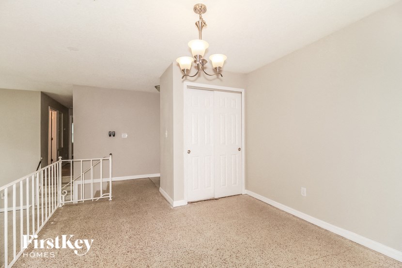 A room with a white door and a chandelier.